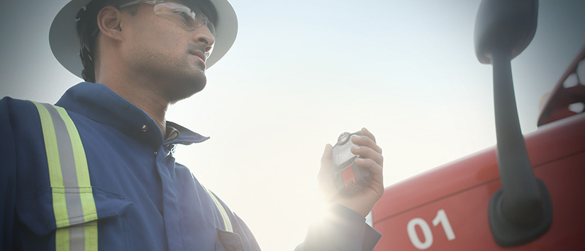 Ouvrier debout à côté d'un camion avec un détecteur de gaz Blackline Safety G7 Bannière 825 x 355